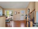 Bright foyer with hardwood floors, a staircase, and a decorative front door, creating a warm welcome at 11446 W 105Th Dr, Broomfield, CO 80021