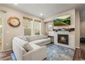 Living room featuring a gas fireplace, sectional sofa, and hardwood floors at 2866 Low Meadow Blvd, Castle Rock, CO 80109