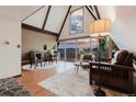 Bright living room with vaulted ceilings, floor-to-ceiling windows offering scenic views, and hardwood floors at 8691 S Warhawk Rd, Conifer, CO 80433