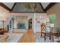 Open floor plan with stone fireplace, hardwood floors, and views of the kitchen and loft area at 8691 S Warhawk Rd, Conifer, CO 80433