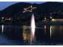 Nighttime aerial view of a town with a water fountain and starlit mountain at 110 Oakdale Dr, Palmer Lake, CO 80132