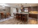 Bright kitchen features a large island with barstool seating, wooden floors, and stylish pendant lighting at 10640 W 46Th Ave, Wheat Ridge, CO 80033