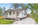Charming home with a covered front porch, and a long driveway leading to a detached garage at 1960 S Franklin St, Denver, CO 80210