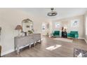 Bright living room featuring hardwood floors, neutral walls, and an ornate gray console under a decorative mirror at 1960 S Franklin St, Denver, CO 80210