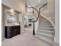 Elegant foyer featuring a curved staircase with white railings, dark accents, and stylish decor at 16361 Parkside Dr, Parker, CO 80134