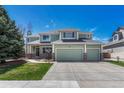 Charming two-story home featuring a well-manicured lawn, three-car garage, and beautiful green exterior at 16361 Parkside Dr, Parker, CO 80134