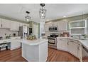 Modern kitchen featuring white cabinets, stainless steel appliances, hardwood floors, and a central island at 16361 Parkside Dr, Parker, CO 80134