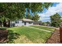 Newly renovated home with lush green lawn and trees at 3100 Gray St, Denver, CO 80214