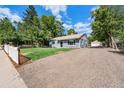 Ranch style home with gravel driveway and mature trees at 3100 Gray St, Denver, CO 80214