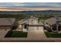 Inviting two-story home with a three car garage, solar panels, a manicured lawn, and sunset mountain views at 3418 Oak Leaf Pl, Highlands Ranch, CO 80129