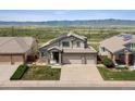 Inviting two-story home with a three car garage, solar panels, a manicured lawn, and stunning mountain views at 3418 Oak Leaf Pl, Highlands Ranch, CO 80129