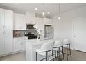 Modern white kitchen with stainless steel appliances and island at 8404 W 52Nd St, Arvada, CO 80002