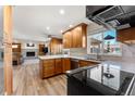 Open-concept kitchen featuring wood cabinets, granite countertops, stainless steel appliances, and hardwood floors at 4725 S Xenon Way, Morrison, CO 80465