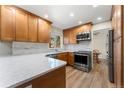 Modern kitchen with granite countertops, stainless steel appliances, and hardwood floors at 4725 S Xenon Way, Morrison, CO 80465