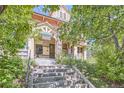 Charming home entrance with stone steps leading to the front door framed by lush greenery, creating an inviting welcome at 1000 N Logan St, Denver, CO 80203