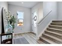 Bright entryway with stairs, wood-look floors, and decorative accents at 11728 Octave Ave, Lone Tree, CO 80134