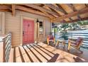 Charming front porch with wooden chairs and a red front door at 1228 Pomegranate Ln, Golden, CO 80401