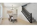 Dining room with modern light fixture, access to stairs and neutral decor at 6087 W 84Th Ave, Arvada, CO 80003