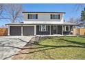 Charming two-story home with fresh exterior paint, an inviting front porch and green lawn at 6087 W 84Th Ave, Arvada, CO 80003