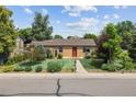 Inviting single-story home featuring a manicured lawn and a walkway leading to the red front door at 998 S Leyden St, Denver, CO 80224