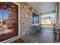 Front porch with stonework, seating area, and solar panels visible at 1429 S Grand Baker Cir, Aurora, CO 80018