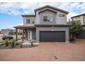 Inviting two-story home with a brick driveway, an attached garage and manicured landscaping at 17996 E 54Th Ave, Denver, CO 80249