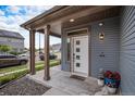 Covered front porch with decorative columns, stylish lighting, and a welcoming entrance at 17996 E 54Th Ave, Denver, CO 80249