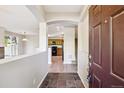 Open concept foyer with tile floors, leading to kitchen and staircase at 10480 Truckee St # B, Commerce City, CO 80022
