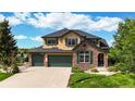 Beautiful two-story home featuring manicured lawn, three-car garage, stone accents, and lush landscaping at 1647 Harris Ct, Erie, CO 80516