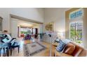 Bright living room featuring hardwood floors, tall ceilings, large windows, and adjacent dining room at 1647 Harris Ct, Erie, CO 80516