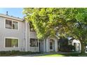 Inviting exterior showcasing an updated townhome with well-kept lawn, mature tree, and covered front porch at 5320 Allison St # 202, Arvada, CO 80002