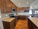 Well-appointed kitchen featuring dark wood cabinets, granite countertops, stainless appliances, and a decorative backsplash at 14545 Barksdaly Way, Keenesburg, CO 80643