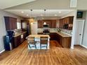 Spacious kitchen features dark wood cabinets, granite countertops, stainless steel appliances, and a center island at 14545 Barksdaly Way, Keenesburg, CO 80643