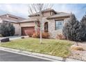 Charming stone home featuring a well-manicured lawn and a quaint, welcoming entrance and a two car garage at 16 Willowcroft Dr, Littleton, CO 80123