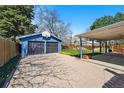 Detached garage with large driveway and basketball hoop on a sunny day at 1335 S Holly St, Denver, CO 80222