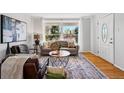 Inviting living room with large window, hardwood floors, and comfortable seating at 1335 S Holly St, Denver, CO 80222
