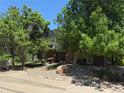 Exterior view of a brick apartment building with lush landscaping at 309 E Highline Cir # 102, Centennial, CO 80122