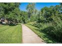 Concrete walking path through lush green grass and vibrant trees at 309 E Highline Cir # 102, Centennial, CO 80122