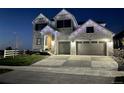 Charming two-story home adorned with festive holiday lights, featuring a spacious driveway and well-manicured lawn at 6860 S Yantley Ct, Aurora, CO 80016