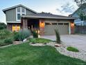 Charming exterior view showcasing a well-lit home and manicured front yard at 8167 S Wabash Ct, Centennial, CO 80112