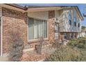 Close up of home's front facade with brick veneer, window with blinds and partial view of entrance at 15341 E Arkansas Pl, Aurora, CO 80017