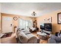 Inviting living room featuring wood floors, neutral tones, modern light fixture, and ample natural light at 15341 E Arkansas Pl, Aurora, CO 80017