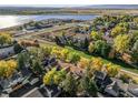 Aerial view of a community with lush trees and a serene lake in the background at 5374 W Canyon Trl # B, Littleton, CO 80128