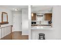 A modern kitchen is viewed from the home's entrance and features quartz countertops and stylish fixtures at 5374 W Canyon Trl # B, Littleton, CO 80128