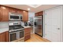Updated kitchen with stainless steel appliances, warm wood cabinetry, and easy access to living areas at 7844 S Eudora Cir, Centennial, CO 80122