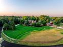 Gorgeous aerial of an estate home with a large lawn, fencing, and mature trees at 5 Random Rd, Cherry Hills Village, CO 80113