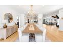 Elegant dining room with contemporary chandelier, long table and seating for ten, flowing into the kitchen at 754 S York St, Denver, CO 80209
