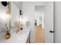Chic powder room with stylish lighting, vanity, and views down long hall at 754 S York St, Denver, CO 80209