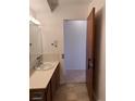 Bathroom with a single sink vanity and door ajar looking into the hallway at 795 S Alton Way # 11C, Denver, CO 80247