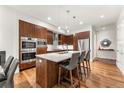 Contemporary kitchen featuring wood cabinetry, an island, and stainless steel appliances at 250 Columbine St # 210, Denver, CO 80206